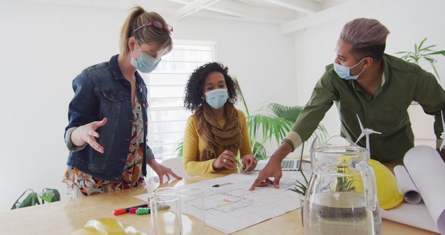 Diverse Coworkers Wearing Face Masks Discussing a Project Indoors - Download Free Stock Images Pikwizard.com