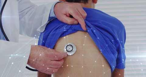 Healthcare Professional Using Stethoscope on Young Boy's Back in Clinic