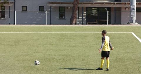 Young Footballer Preparing Kick on School Field