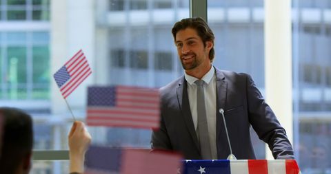 Confident Businessman Giving Motivational Speech with American Flags
