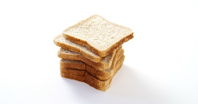A stack of whole wheat bread slices is neatly arranged against a white background, with copy space. Whole wheat bread is a nutritious staple in many diets, offering fiber and essential nutrients.