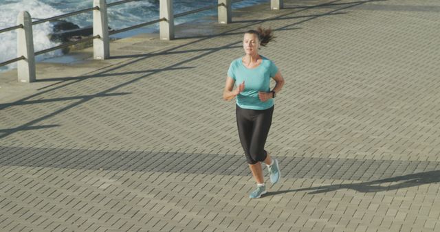 Woman jogging on waterfront path in sunny weather - Download Free Stock Images Pikwizard.com