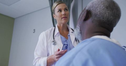 Female doctor consulting African American male patient in hospital exam room 3