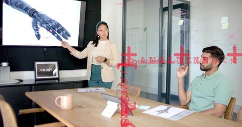 Female professional presenting prosthetic hand design to team in modern boardroom