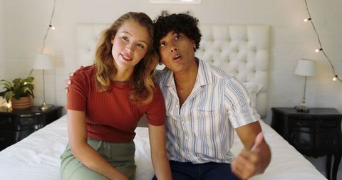 Happy Couple Relaxing on Comfortably Bed with String Lights