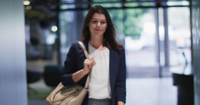 Portrait of smiling caucasian businesswoman with brown hair walking in modern office. business and business people in office concept.