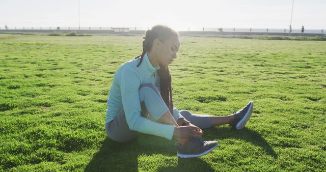 Young Woman Relaxing on Grass in Sportswear, Sunlit Afternoon - Download Free Stock Images Pikwizard.com