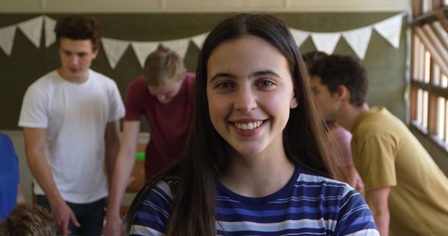 Young Woman Smiling at Camera with Group of Friends in Background - Download Free Stock Images Pikwizard.com