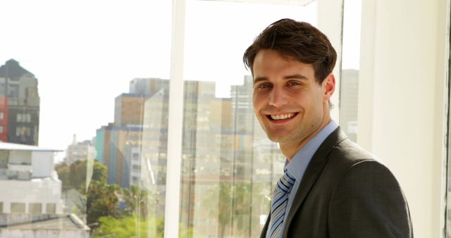 Smiling Young Businessman in Modern Office with City Skyline View - Download Free Stock Images Pikwizard.com