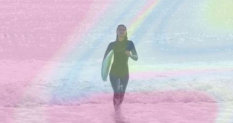 Surfer with surfboard emerging through pastel waves