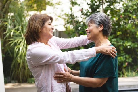 Senior Friends Hugging in Peaceful Garden Setting