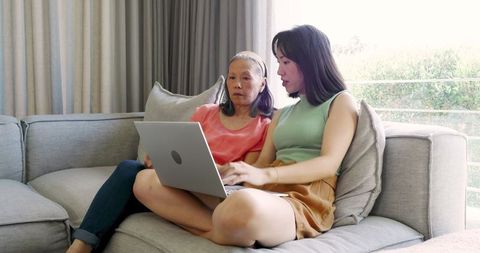 Mother and daughter connection time at home using laptop