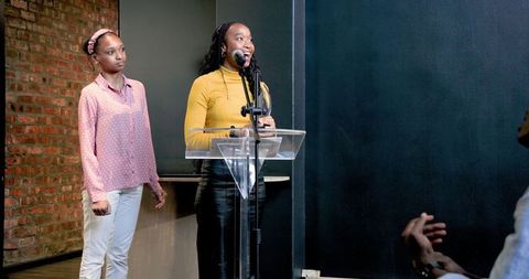 Confident woman presenting at podium in professional setting