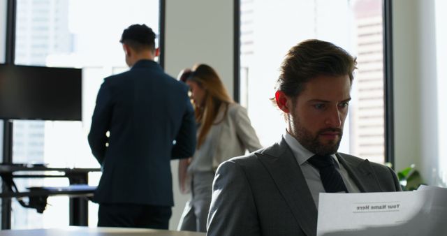 Focused Businessman Reading Document in Modern Office - Download Free Stock Images Pikwizard.com