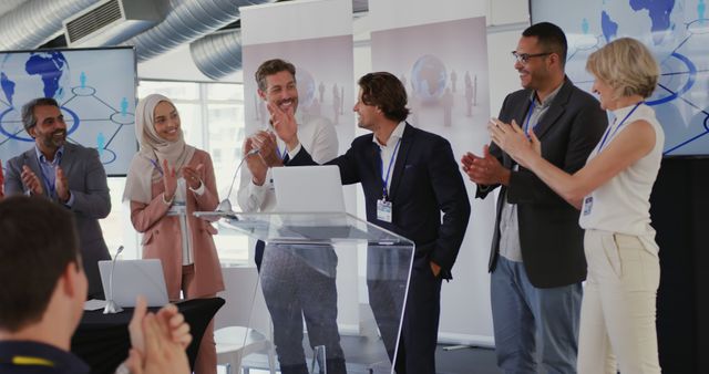 Diverse team professionals clapping during successful business presentation. Ideal for use in corporate communication, teamwork promotion, business conferences, seminars, corporate training materials, diversity & inclusion initiatives, and professional success stories.