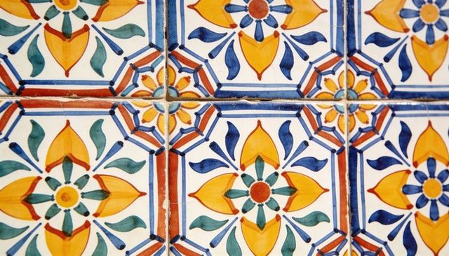 Hand-painted glazed ceramic tiles featuring yellow blue orange floral geometric pattern