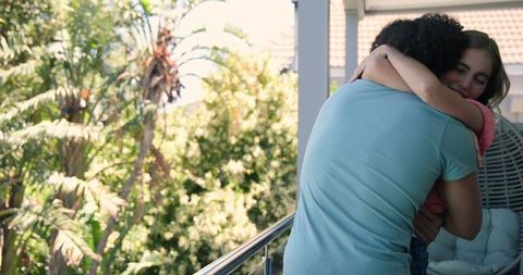 Young couple embracing after marriage proposal on balcony