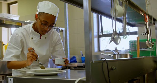 Chef plating a dish in a restaurant kitchen, perfect for use in culinary blogs, cooking tutorials, restaurant promotions, and articles related to professional cooking and culinary arts.