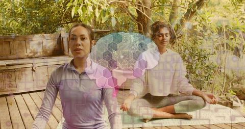 Practicing outdoor yoga duo meditating on backyard deck with hexagonal digital overlay