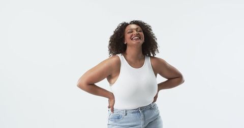 Confident Plus Size Woman Smiling in Studio with Curly Hair