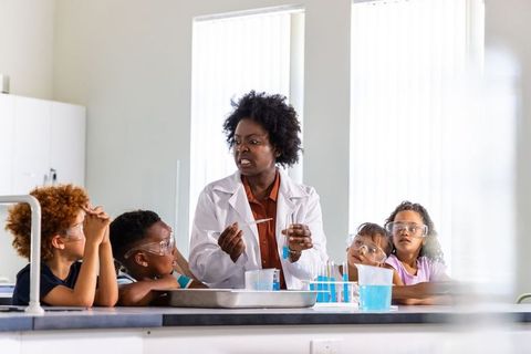 African american teacher leading interactive science experiment with elementary students