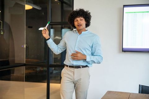 Confident professional presenting spreadsheet in modern office