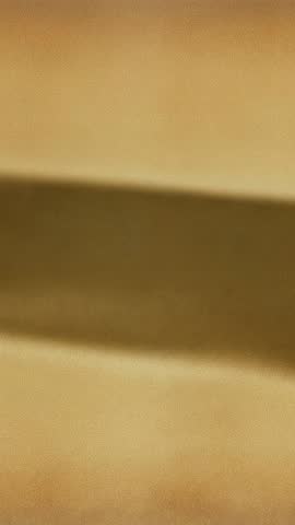 Vertical video showing shifting tan wall shadow minimalist textured abstract motion