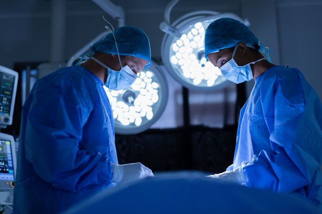 Side view of attentive surgeons performing operation in operating room