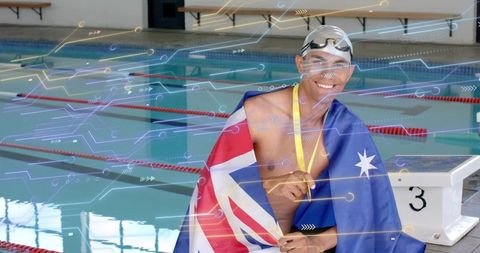 Triumphant swimmer draping Australian flag wearing gold medal beside pool starting block