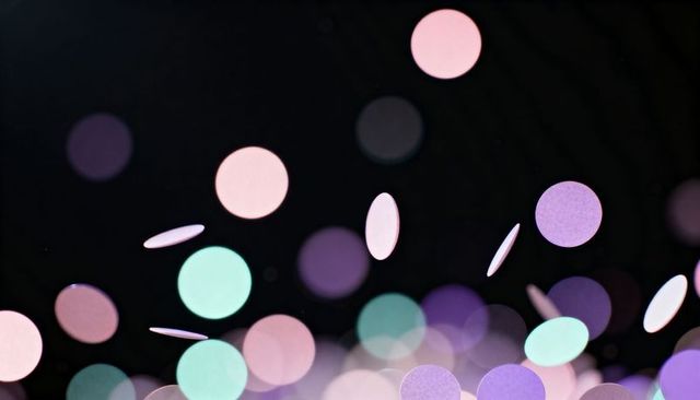 Floating pastel confetti orbs glowing over dark backdrop creating dreamy bokeh layers