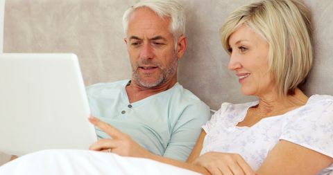 Mature Couple Enjoying Laptop Time in Bed