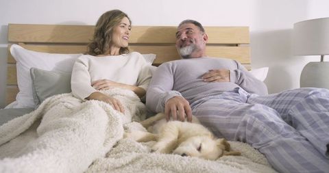 Couple Relaxing in Stylish Bedroom with Sleeping Puppy
