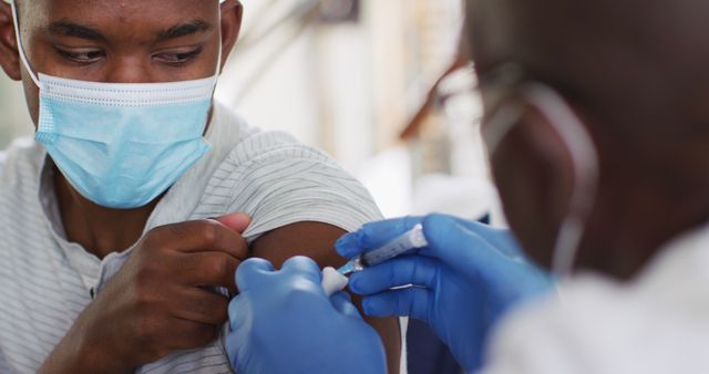 Doctor giving vaccine injection to young man - Download Free Stock Images Pikwizard.com