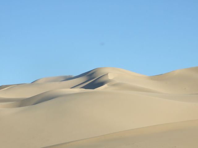 Serene Sand Dunes Under Clear Blue Sky - Download Free Stock Photos Pikwizard.com
