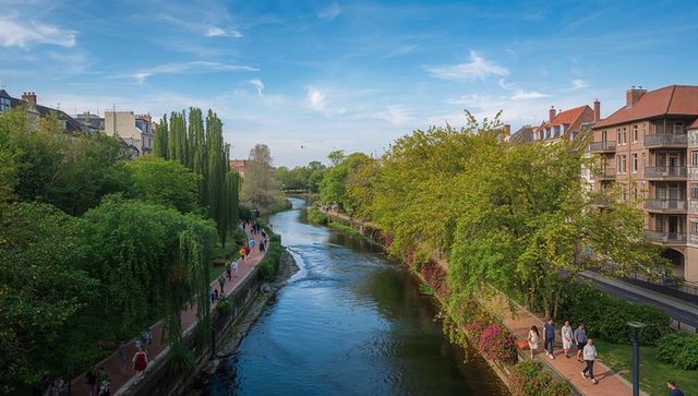 Flowing river promenade with tree-lined walkways, riverside buildings, leisurely pedestrians