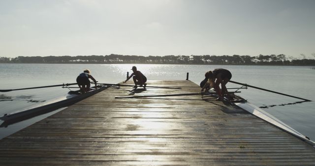 Rowers Preparing Boats at Sunset on the Pier - Download Free Stock Images Pikwizard.com