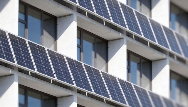 Tilted solar panel facade on urban building generating clean energy and modular geometry