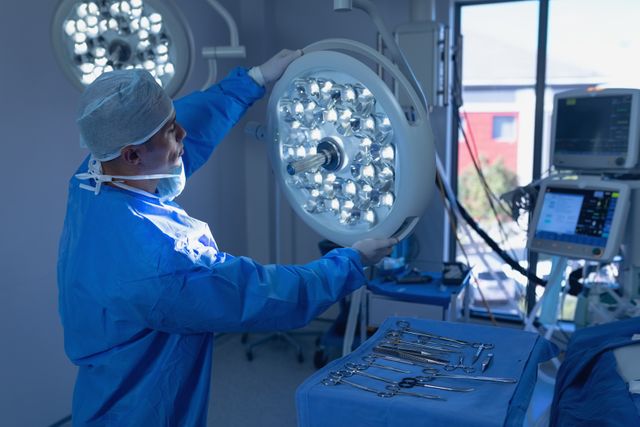 Male surgeon adjusting surgical light in operating room at hospital