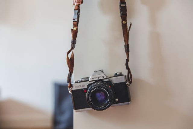 Vintage Minolta SLR Camera Hanging on Wall with Leather Strap - Download Free Stock Photos Pikwizard.com