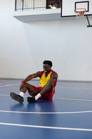 Basketball player nursing injury on indoor court