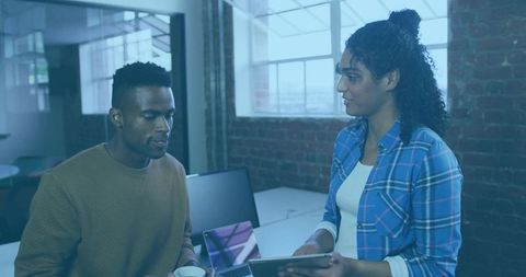 Collaborating Coworkers Sharing Tablet and Laptop in Modern Industrial Brick Office
