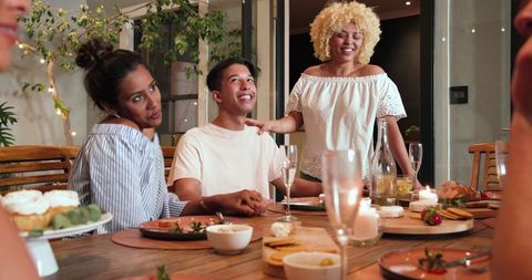 Friends celebrating gathering with toasts at dinner party