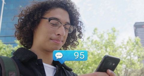 Young Man Checking Social Messages in Urban Park