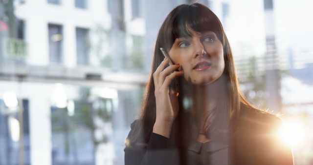 Businesswoman Talking on Smartphone by Window in Modern Office - Download Free Stock Images Pikwizard.com