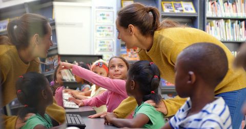 Teacher Guiding Diverse Children Using Computers in Library - Download Free Stock Images Pikwizard.com