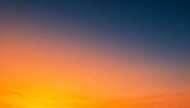 Sunset gradient sky glowing orange to deep blue minimal twilight background wispy clouds
