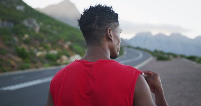 Fit man preparing for an early morning run on scenic mountain road - Download Free Stock Images Pikwizard.com