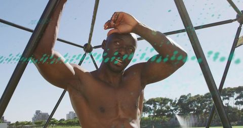 Shielding athletic man gripping geodesic dome bars under bright sun with teal streaks