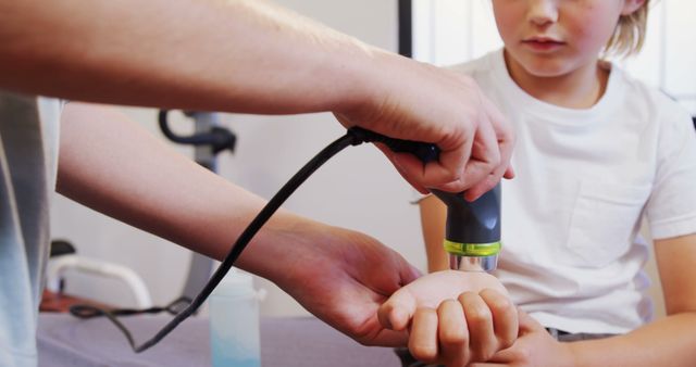 Medical professional checking a child's hand with an ultrasound device. Useful for healthcare, pediatrics, medical technology, and clinical examination topics. Ideal for illustrating pediatric care, diagnosis, and modern medical practices.