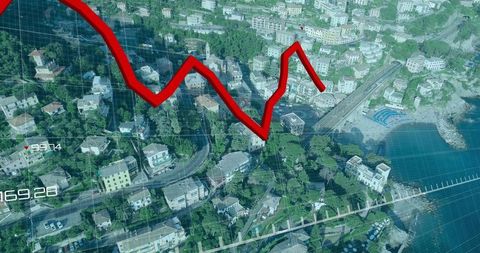 Aerial coastal town with red financial trend line showing property market decline